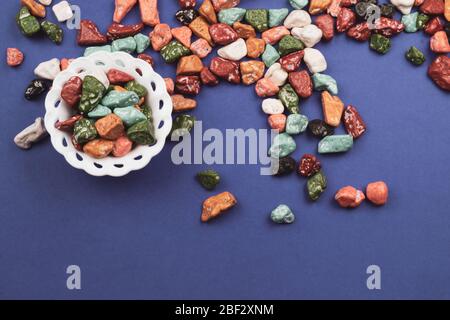 Süßigkeiten-Schüssel mit Süßigkeiten in Form von farbigen Steinen. Bunte Süßigkeiten Stockfoto