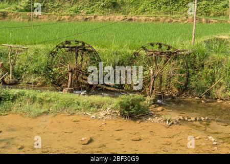 Wasserräder, die die Schwerkraft antreiben, führen die Bewässerung für die Reisterrassen im Pu Luong Nature Reserve, Vietnam Stockfoto