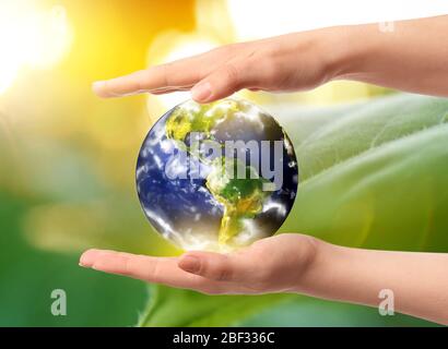 Hände der Frau mit Modell der Erde im Freien Stockfoto