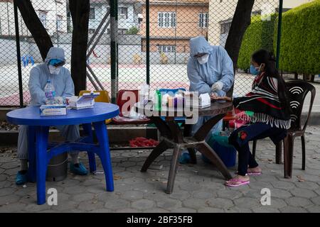 Kathmandu, Nepal. April 2020. Ein Gesundheitsarbeiter, der in einem Schutzanzug gekleidet ist, nimmt Blutproben von einer Frau, die vor kurzem eine Reisegeschichte außerhalb des Landes im provisorischen Schnelltestzentrum für Coronavirus (COVID-19) in Kathmandu hat. Nepal hat in den letzten 48 Stunden keine neuen Fälle von Coronavirus gemeldet. (Foto von Prabin Ranabhat/Pacific Press) Quelle: Pacific Press Agency/Alamy Live News Stockfoto