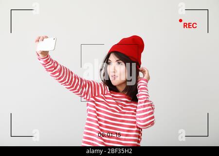 Porträt der schönen asiatischen Blogger, die Selfie auf hellem Hintergrund Stockfoto