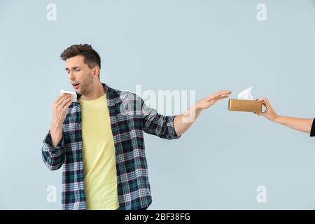 Junger Mann, der an Allergie auf hellem Hintergrund leidet Stockfoto