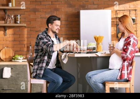 Mann mit schwangerer Frau Kochen in der Küche Stockfoto