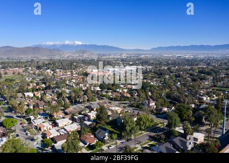 Luftaufnahme eines Wohnviertels von Riverside California an einem klaren Tag mit schneebedeckten Gipfeln in der Ferne Stockfoto