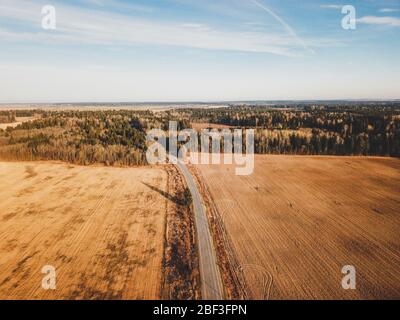 Luftaufnahme von Straßen und landwirtschaftlichen Feldern. Weite Wiesenlandschaft mit Fahrbahn Stockfoto