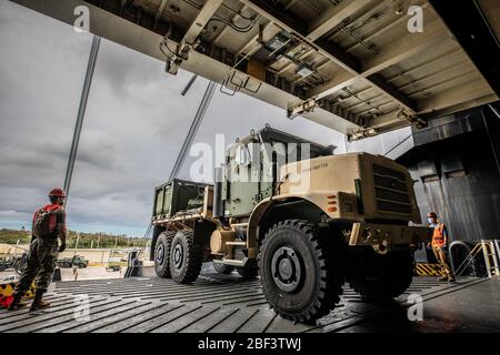 MARINESTÜTZPUNKT GUAM (16. April 2020) WÄHREND eines Betriebs zur Be- und Entladung von Ausrüstung für den Bau einer Expeditionary Medical Facility (EMF) wird EIN mitteltaktischer Fahrzeugersatz des US-MARINESTÜTZPUNKTES auf das Frachtschiff USNS Dahl (T-AKR-312) der Watson-Klasse geladen. Das EMF wird erweiterte medizinische Fähigkeiten zur Unterstützung der COVID-19-Reaktion des DoD bereitstellen und es den Truppen ermöglichen, Guam und die Region zu unterstützen, wenn eine Mission zur Unterstützung ziviler Behörden zur Verteidigung beantragt wird. (USA Marine Corps Foto von Sgt. Hailey D. Clay) Stockfoto