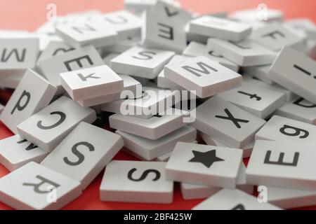 Stapel von Buchstaben-Fliesen auf einem roten Hintergrund Stockfoto