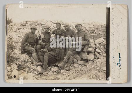 Fotopostkarte von Soldaten im Ersten Weltkrieg in Verdun. Eine Fotopostkarte von Oscar Calmeise (ganz rechts) und fünf weiteren unbekannten Soldaten während des Ersten Weltkriegs. Die Gruppe sitzt auf einem Steinhaufen in Verdun, Frankreich. Die Männer schauen alle auf die Kamera. Stockfoto