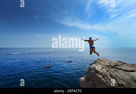 Der Sprung - Sprung in die Adria von den Klippen unter den Mauern der Altstadt von Dubrovnik, Kroatien. Stockfoto