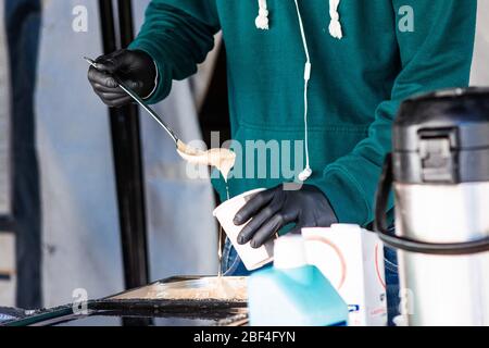 Berlin, Deutschland. April 2020. Ein Mitarbeiter einer Gaststättengesellschaft bereitet in Berlin, der Hauptstadt Deutschlands, am 16. April 2020 kostenlose Speisen zu. Die Neuinfektionsrate mit COVID-19 in Deutschland blieb unter den Spitzenzeiten, da die Zahl der bestätigten Fälle innerhalb eines Tages um 2,866 auf 130,450 gestiegen ist, teilte das Robert Koch-Institut (RKI) am Donnerstag mit. Kredit: Binh Truong/Xinhua/Alamy Live News Stockfoto