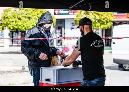 Berlin, Deutschland. April 2020. Ein Mitarbeiter (R) einer Catering-Firma stellt einem Mann in Berlin, der Hauptstadt von Deutschland, am 16. April 2020 kostenlose Speisen zur Verfügung. Die Neuinfektionsrate mit COVID-19 in Deutschland blieb unter den Spitzenzeiten, da die Zahl der bestätigten Fälle innerhalb eines Tages um 2,866 auf 130,450 gestiegen ist, teilte das Robert Koch-Institut (RKI) am Donnerstag mit. Kredit: Binh Truong/Xinhua/Alamy Live News Stockfoto