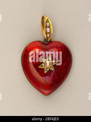 Medaillon in Form eines Herzens. Herzförmig, emailliertes Rot, mit Perle und kleinen Diamanten in der Mitte; auf der Rückseite ein kreisförmiges Medaillon Fach; Schleife und Ring mit drei Birnenplatte. Stockfoto