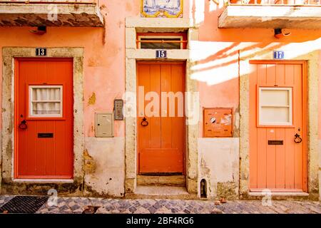 Drei orangefarbene Türen in einem Korallengebäude im Stadtteil Alfama von Lissabon Portugal Stockfoto