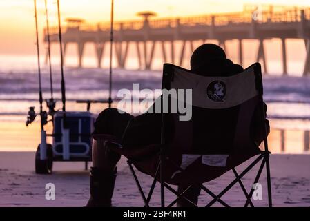 Surf Fisherman genießt einen friedlichen und farbenfrohen Sonnenaufgang am Jacksonville Beach im Nordosten Floridas. (USA) Stockfoto