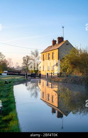 Veröden Lock Keepers Cottage am oxford Kanal an einem Frühlingsmorgen bei Sonnenaufgang. Nahe Kings Sutton, Oxfordshire / Northamptonshire Grenze, England Stockfoto