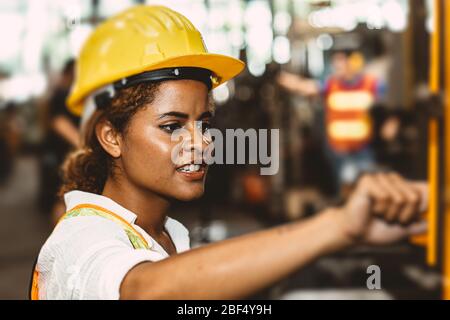 Amerikanische schwarze Frauen teen Arbeiter Arbeit in der Industrie-Fabrik mit schweren Stahlmaschine. Stockfoto