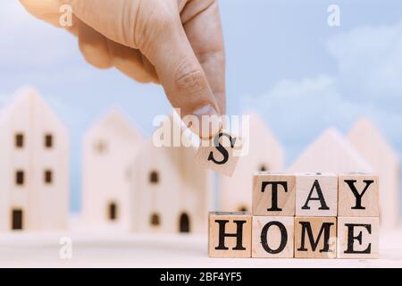 Holzblock 'Stay Home' zur Vermeidung der Verbreitung von Coronavirus Selbstisolierung oder Arbeit zu Hause Kampagne. Stockfoto