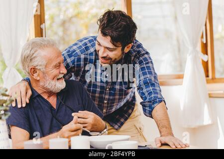 Junger Mann Liebe und Pflege ältere Essen Mittagessen Mahlzeit für sicher und zu Hause bleiben glücklich Lächeln Familie. Stockfoto