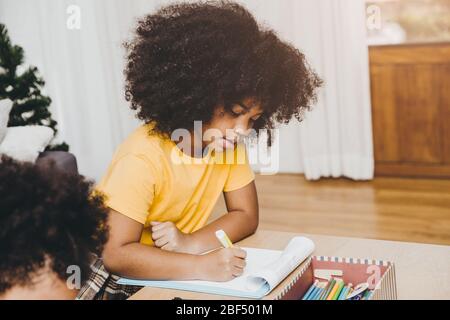 Kinder der amerikanischen schwarzen Vorschulkindern lernen ihre Hausaufgaben mit ihrer Schwester, die zu Hause zusammen lebt. Stockfoto