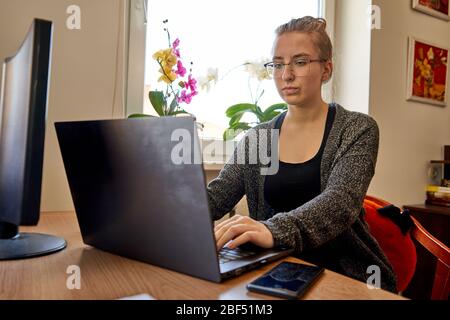 Young woman working on laptop from home. Stockfoto