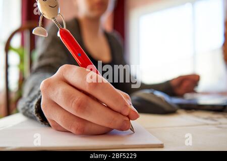 Frau schreibt Text auf Papier. Home Office. Arbeiten von zu Hause aus. Stockfoto