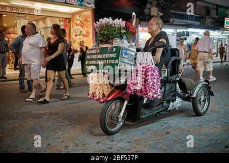 Behinderter Mann im Rollstuhl, der durch den Verkauf von Blumen arbeitet Stockfoto