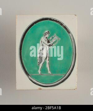 Kachel. Vertikales Rechteck. Weiß glasierte Boden; aufrecht ovale schwarze Transfer-bedruckte Rahmen umschließen grünen Bereich, gegen die, in schwarz auf weiß, ist eine Figur von Orpheus oder Apollo halten eine Leier. Stockfoto