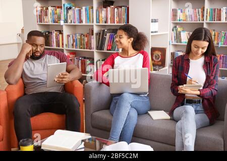 Junge Studenten, die sich auf die Prüfung in der Bibliothek vorbereiten Stockfoto