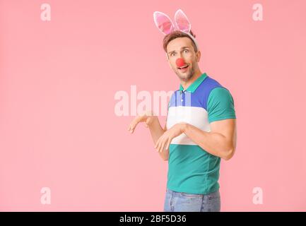 Mann in lustiger Verkleidung auf Farbhintergrund. April Narrenfeier Stockfoto