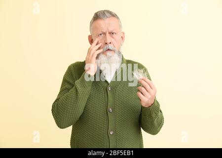 Senior Mann mit Haarausfall Problem auf Farbhintergrund Stockfoto