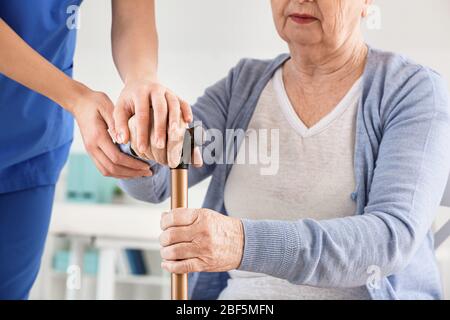 Ärztin mit älterer Frau, die an Parkinson-Syndrom in der Klinik leidet Stockfoto