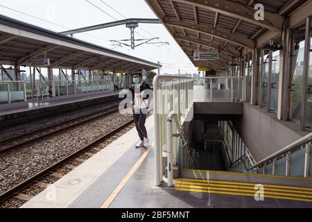 Hsinchu, Taiwan - 11. April 2020: Junger Mann allein auf Bahnsteig am Bahnhof Qianjia, der auf den Zug wartet Stockfoto