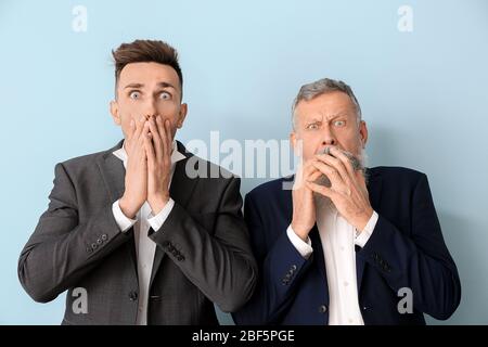 Angst Senior Mann und sein erwachsener Sohn auf farbigen Hintergrund Stockfoto