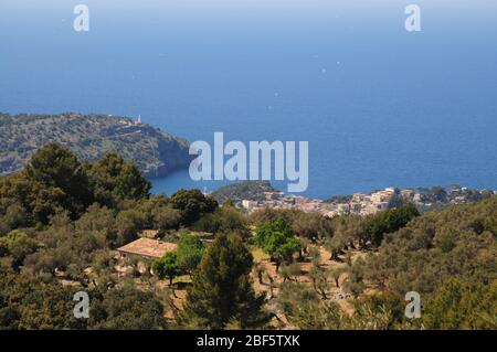 Blick hinunter auf die Bucht von Port de Soller auf Mallorca. Der Leuchtturm von Cap Gros markiert den Eingang zur Bucht. Stockfoto