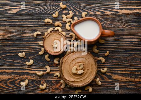 Cashewbutter mit Milch auf Holzhintergrund Stockfoto