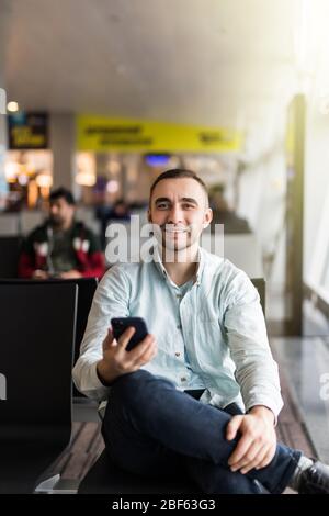 Mann in der Halle-Flughafen. SMS auf Handy tippen Stockfoto