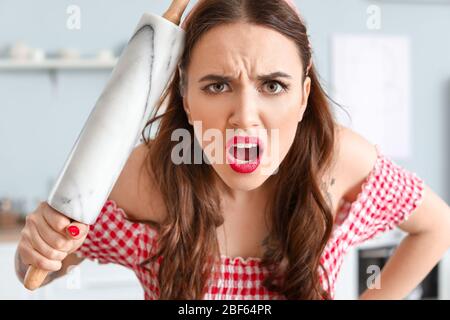 Lustige wütende Hausfrau in der Küche Stockfoto