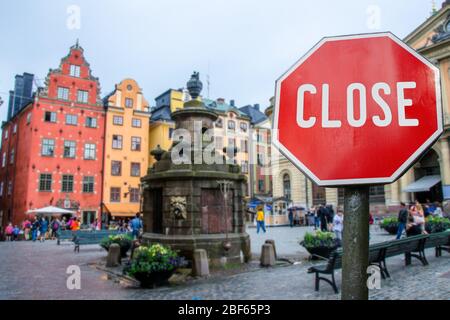 Geschlossenes, geschlossenes Stoppschild mit Blick auf das historische alte Towin in Stockholm, Schweden. Geschlossene Einrichtungen wegen Corona-Virus. COVID-19 Pandemiequarantäne. Stockfoto