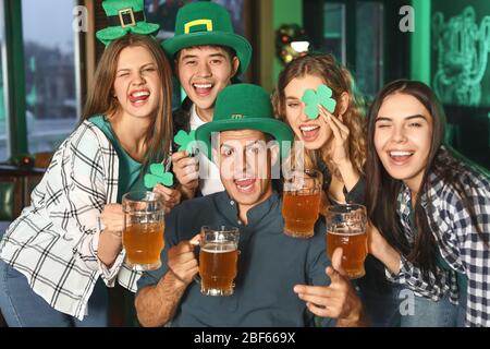 Junge Freunde feiern St. Patrick's Day in der Kneipe Stockfoto