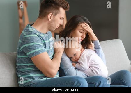 Junger Vater mit Baby und Frau, die zu Hause an postnataler Depression leidet Stockfoto