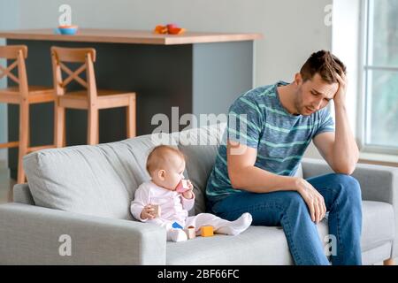 Junger Mann, der zu Hause an postnataler Depression leidet Stockfoto