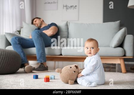 Junger Mann, der zu Hause an postnataler Depression leidet Stockfoto