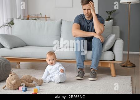 Junger Mann, der zu Hause an postnataler Depression leidet Stockfoto