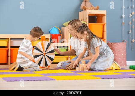 Kindermädchen und niedliche kleine Kinder spielen zu Hause Stockfoto