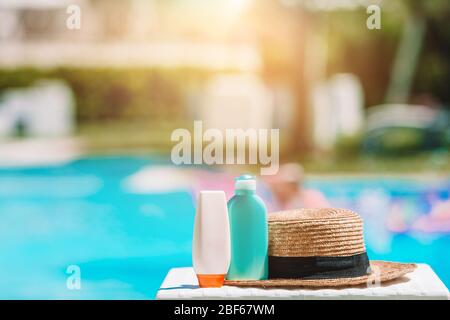 Sonnencreme-Flaschen, Brillen, Seesterne am Rand des Pools Stockfoto