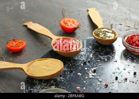 Verschiedene leckere Saucen auf dunklem Hintergrund Stockfoto
