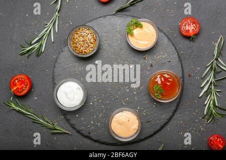 Verschiedene leckere Saucen auf dunklem Hintergrund Stockfoto