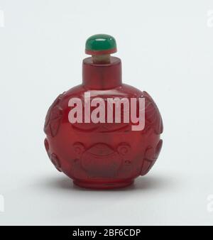 Schnupftabak-Flasche. Monotone Kameoglas, rubinrot; geschnitzt mit acht kostbaren Emblemen des Glücks; Rad des Gesetzes, Muschelschale, Schirm Baldachin, Lotusblume, Fischpaar, endloser Knoten. Abgeflachte, globose Form. Stockfoto