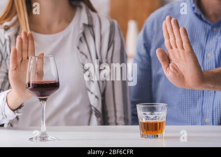 Das Paar weigert sich, Wein und Whisky zu trinken. Konzept des Alkoholismus Stockfoto