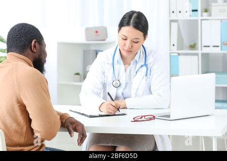 Junger Mann, der Kardiologin in der Klinik besucht Stockfoto